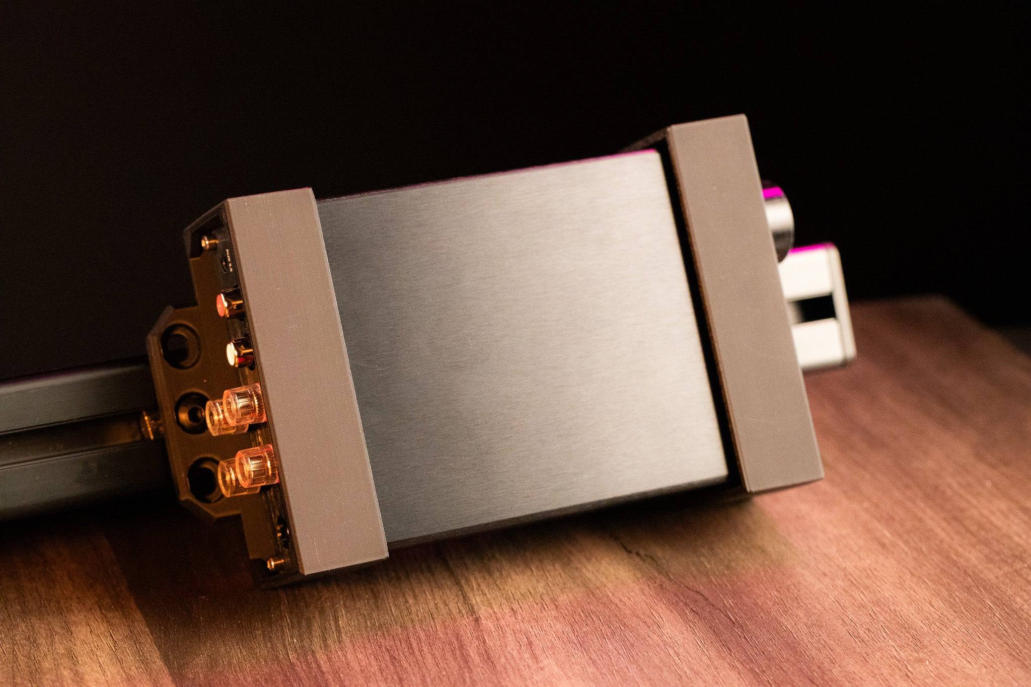 SimSportGadget AIYIMA A07 amplifier bracket mounted on a sim racing aluminum rig for power brick support.