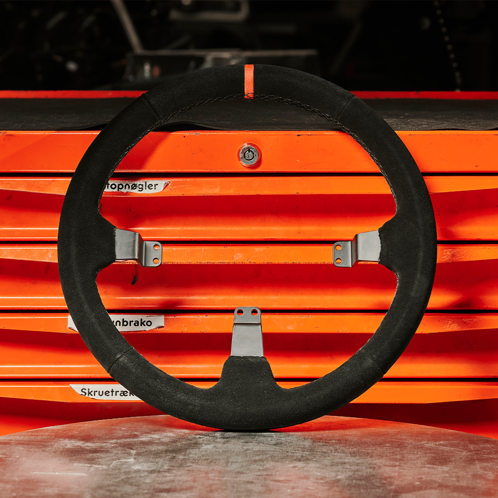 Asetek SimSports Dished Suede Rim wheel rim with rally and drift-inspired design, shown in a racing environment.
