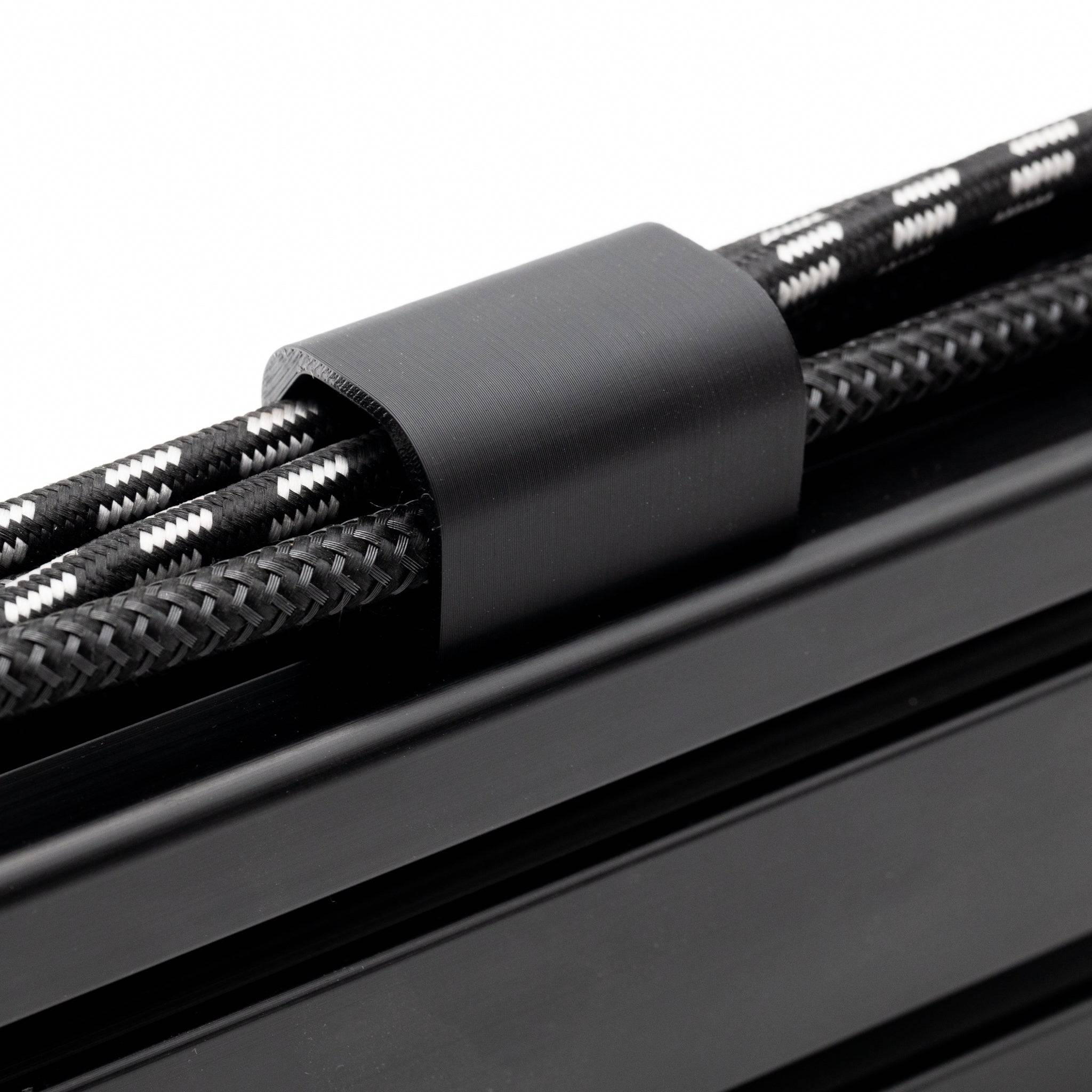 SimSportGadget cable management channel clip securing a thick cable for organized wiring and easy access.