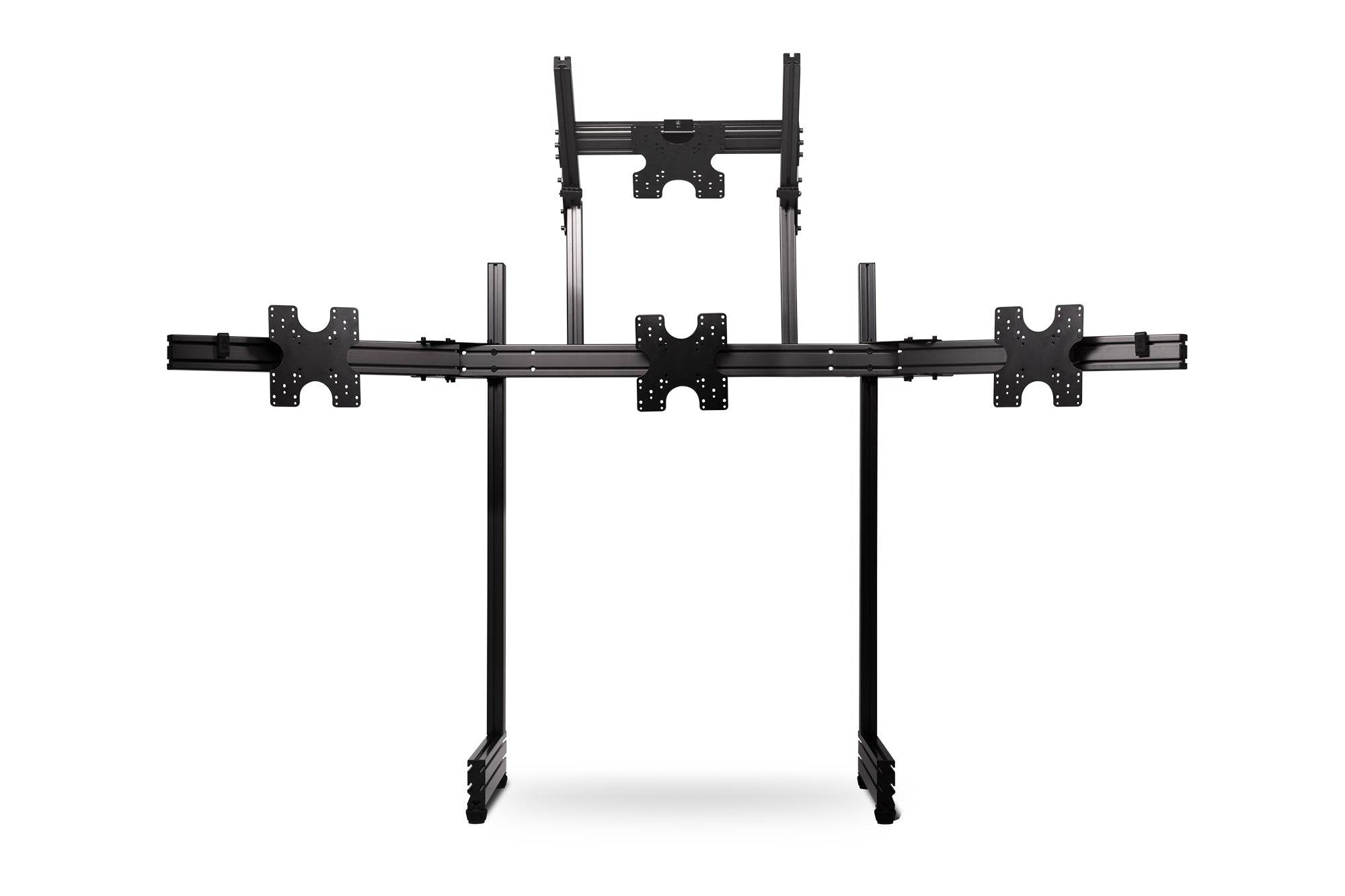 Next Level Racing Elite freestanding quad monitor stand in carbon grey holding four monitors for gaming or office setup.