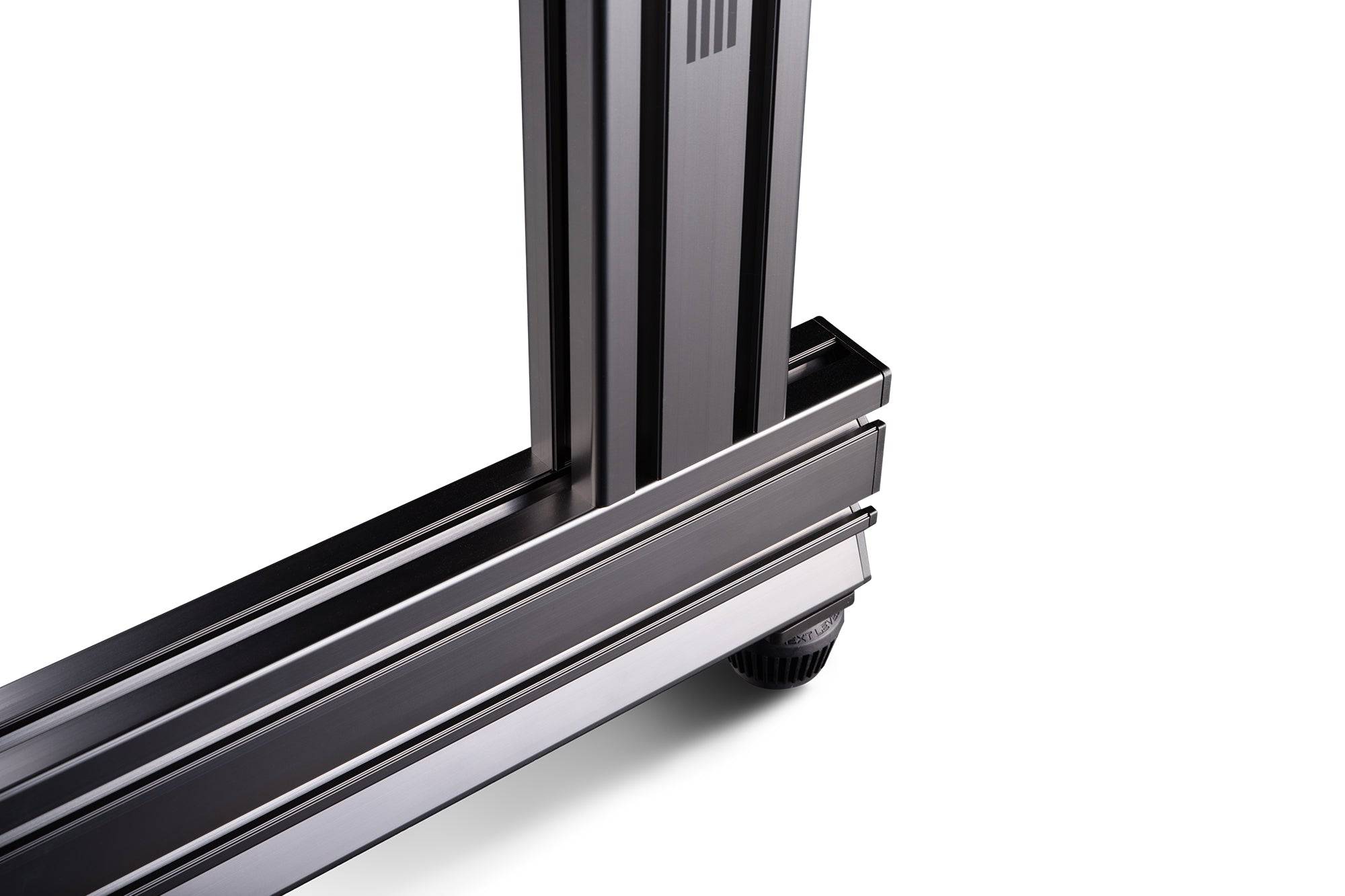 Next Level Racing Elite freestanding quad monitor stand in carbon grey, holding four monitors securely for gaming or work setup.
